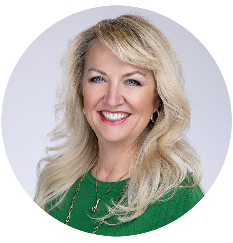 Headshot of Michelle Rene, she is wearing a green long sleeve with nice gold jewelry